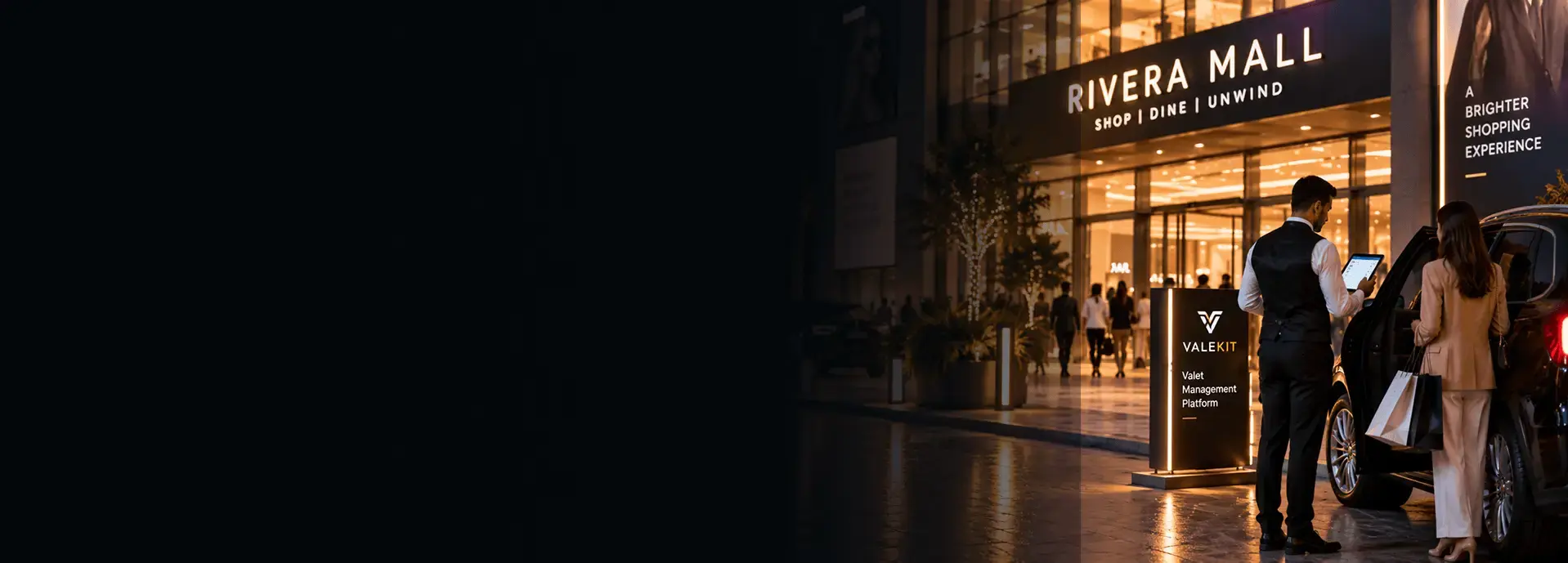 Valet attendant using ValeKit mall and retail valet parking software on a tablet at a shopping mall entrance at night