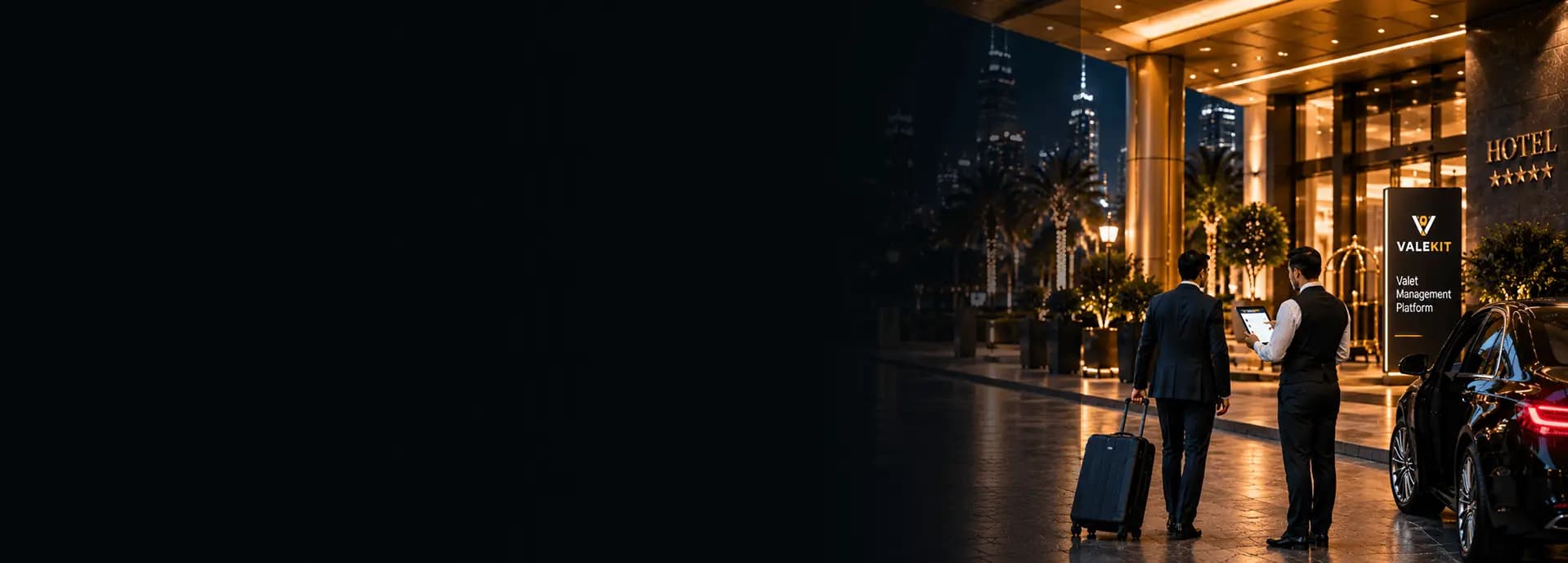 Valet attendant using ValeKit hotel valet parking software on a tablet at a hotel entrance at night